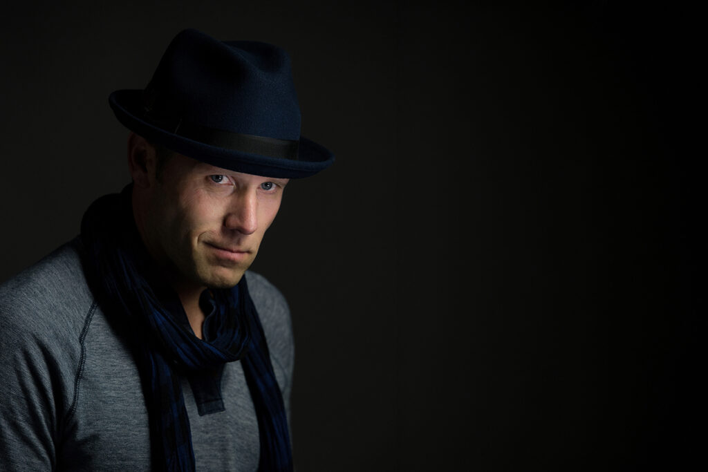 Portrait photographed with dramatic directional studio lighting demonstrating controlled lighting techniques